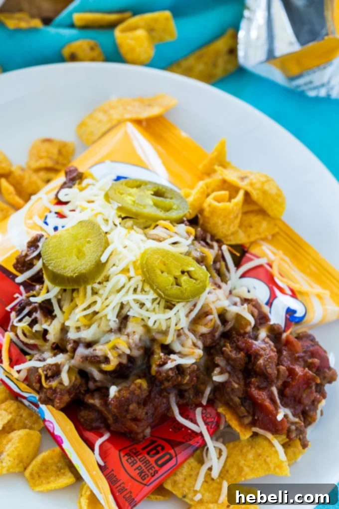 Frito Fiesta in a Pouch 3 Frito Pie in a Bag, showcasing the rich Texas-style chili being carefully scooped into the Frito bag, eagerly awaiting its cheese and diverse toppings.