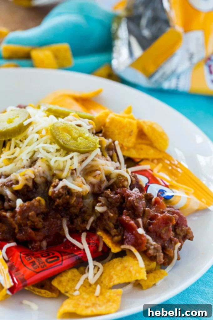 Frito Fiesta in a Pouch 4 Close-up of a Frito bag generously filled with savory Texas-style chili, lavishly topped with melted cheese, and ready to be devoured.