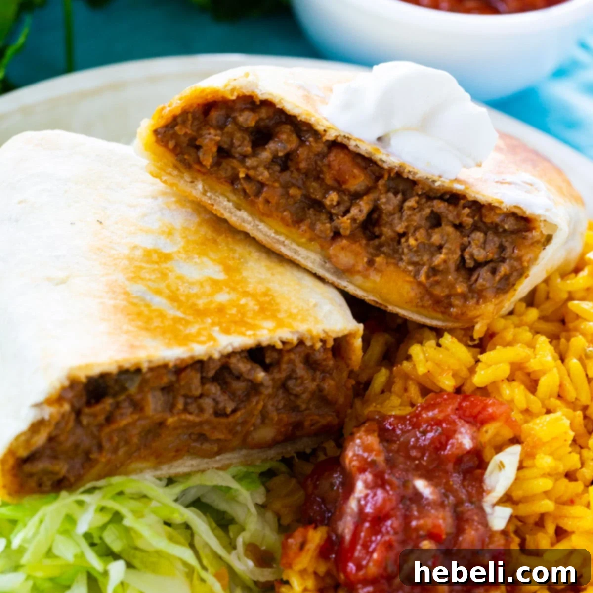 Hearty Beef & Bean Burritos 2 Hearty Beef and Bean Burritos served on a rustic plate alongside fluffy Mexican rice, garnished with fresh cilantro, ready to be enjoyed.