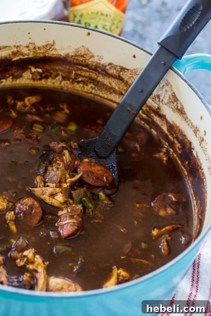 Gumbo in 30 Minutes 3 Hearty 30-Minute Gumbo simmering with chicken and slices of spicy Andouille sausage, showcasing the rich, dark broth.