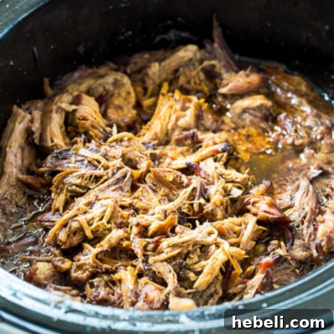 Teriyaki Pulled Pork simmering in a 6-quart slow cooker, showcasing the rich, glistening sauce and the pork beginning to tenderize.