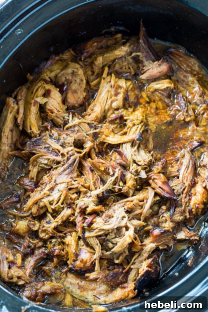 Shredded Crock Pot Teriyaki Pulled Pork in the slow cooker, bathed in its rich sauce, ready to be served.