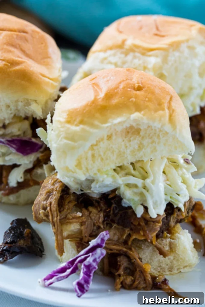 Close-up of perfectly shredded Crock Pot Teriyaki Pulled Pork, garnished and ready to be served, emphasizing its succulent texture.