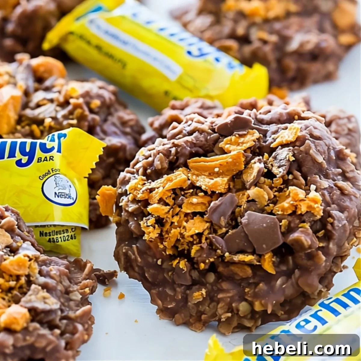 No-Bake Butterfinger Oatmeal Cookies with butterfinger candy bars, arranged enticingly.