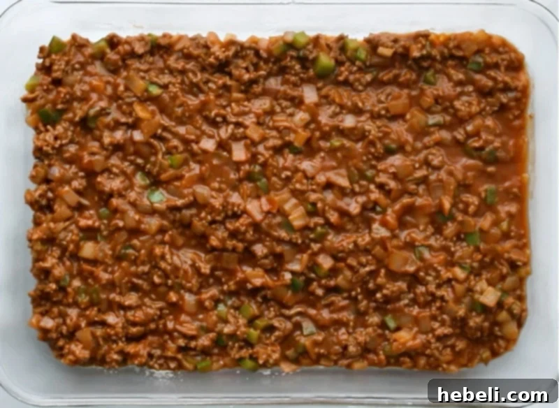Sloppy Joe layer spread evenly in the baking dish, forming the base.