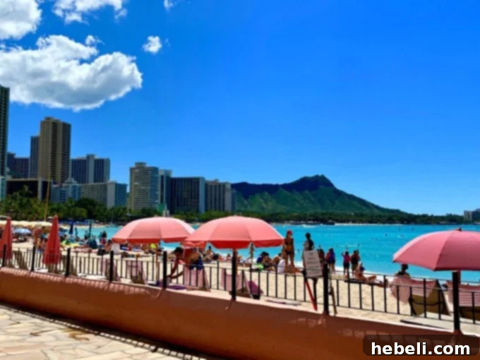 Small, inviting pool area at The Royal Hawaiian, surrounded by lush greenery and lounge chairs