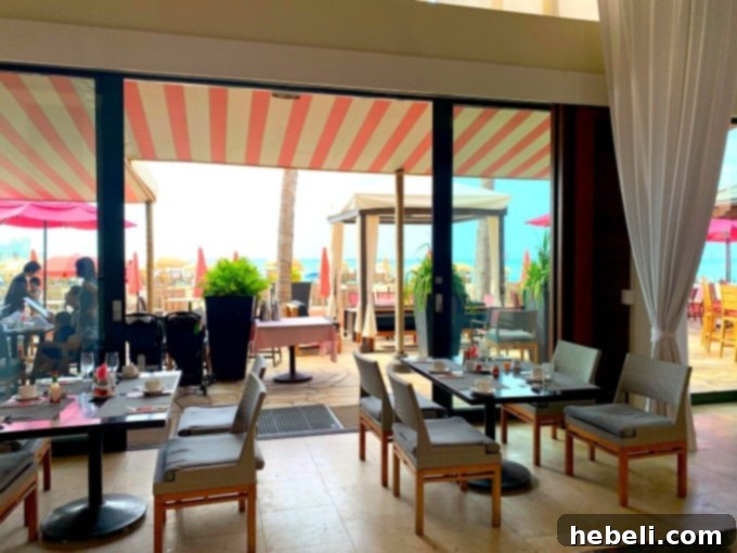 Elegant breakfast setting at The Royal Hawaiian's Surf Lanai restaurant with guests enjoying meals and stunning ocean views