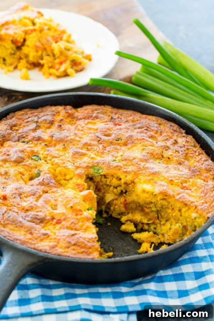 A generous slice of Crawfish Cornbread, showing the moist interior filled with crawfish, cheese, and vegetables
