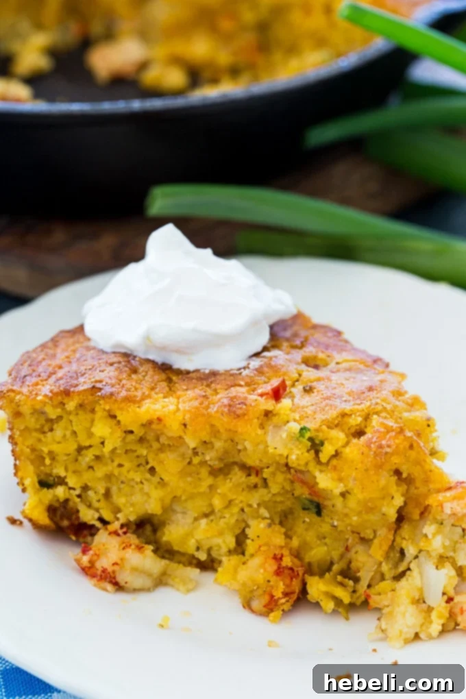 Close-up of a Crawfish Cornbread slice on a plate, highlighting its appetizing appearance and texture