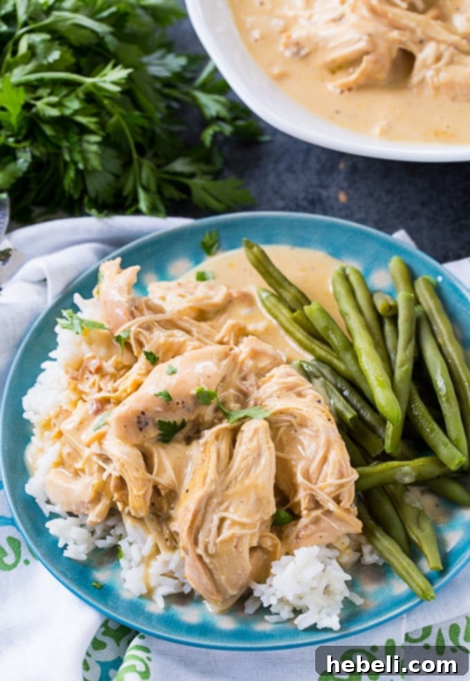 Easy Slow Cooker Chicken and Gravy 4 Crock Pot Chicken and Gravy served over white rice with a side of green beans.