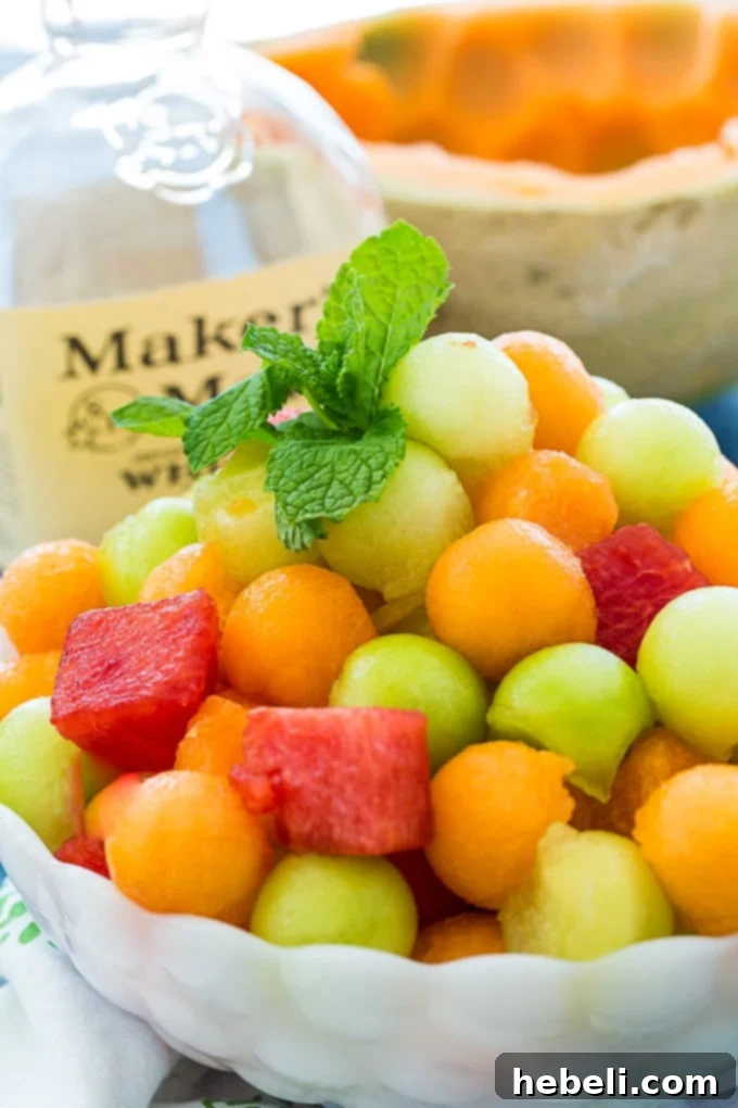 A close-up shot of three different melon balls (watermelon, honeydew, cantaloupe) ready for the Mint Julep Fruit Salad.