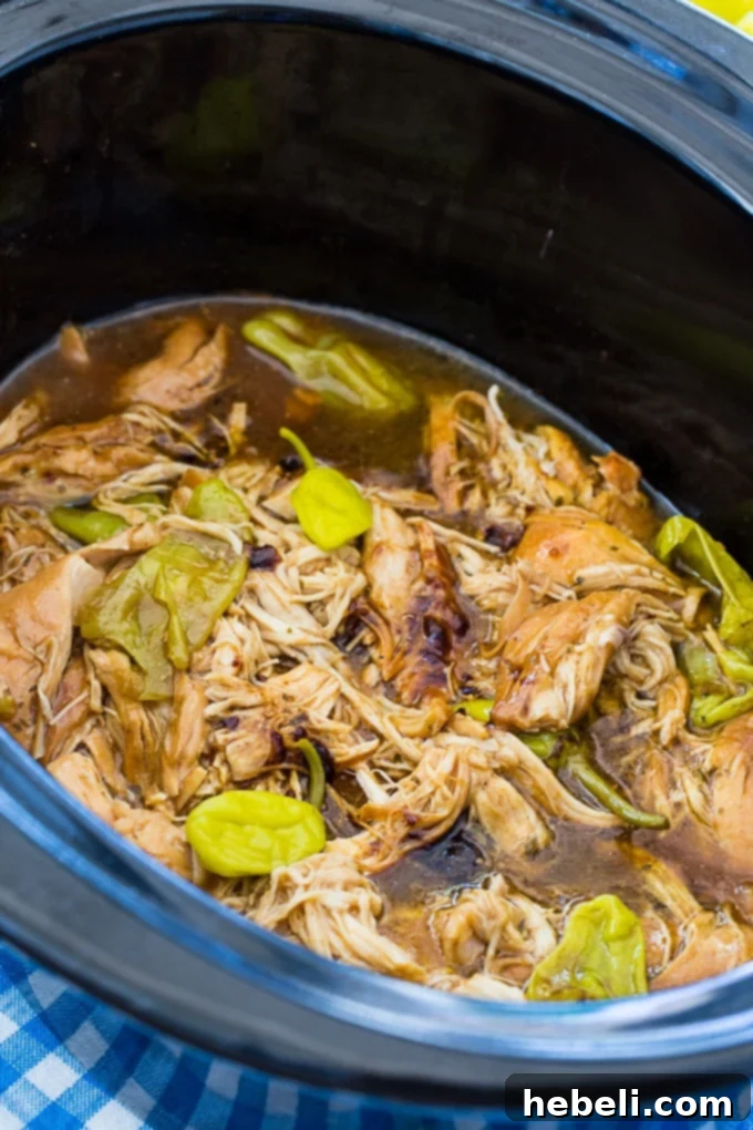 Crock Pot Mississippi Chicken with shredded chicken and sauce.