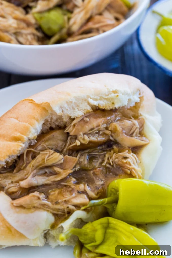 Crock Pot Mississippi Chicken served on a toasted bun with melted cheese.