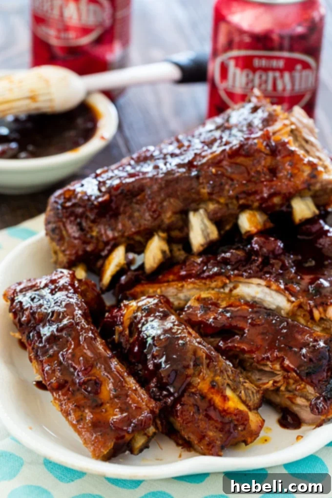 A stack of beautifully glazed baby back ribs presented on a plate, ready to be enjoyed.