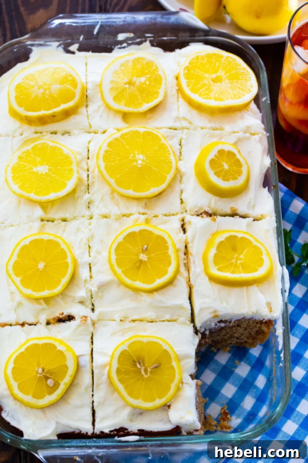 Southern Sweet Tea Lemonade Cake 3 A freshly baked Sweet Tea and Lemonade Cake in a 9x13-inch pan, beautifully topped with delicate lemon slices for garnish.