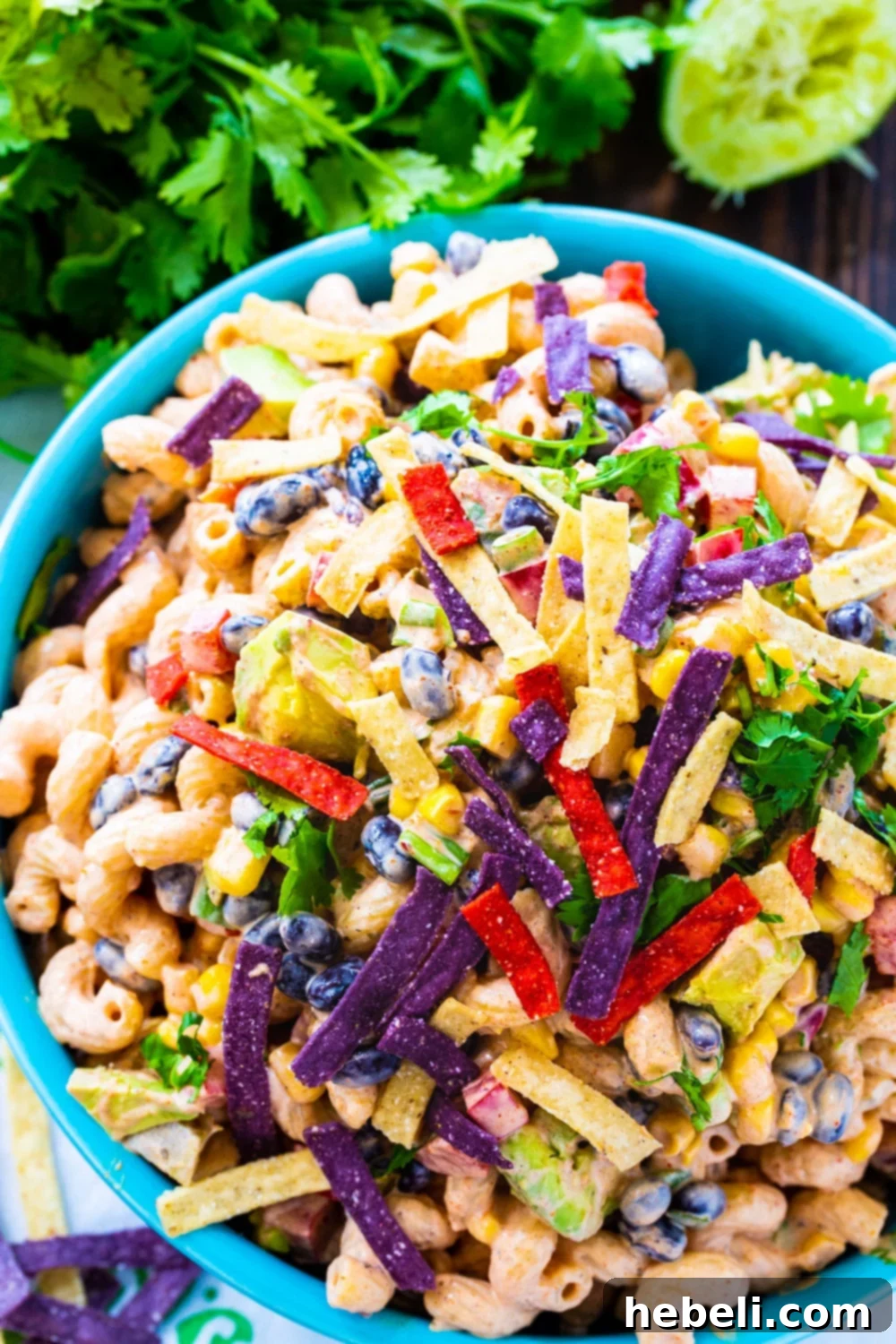 Easy Tex-Mex Pasta Salad Recipe 3 Close-up shot of Tex-Mex Pasta Salad in a blue bowl, garnished with fresh cilantro, highlighting the vibrant colors and creamy dressing.