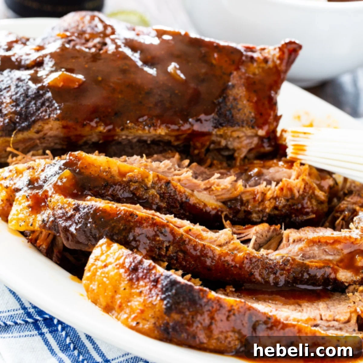 Tender slices of slow cooker brisket arranged beautifully on a serving plate, ready to be enjoyed.