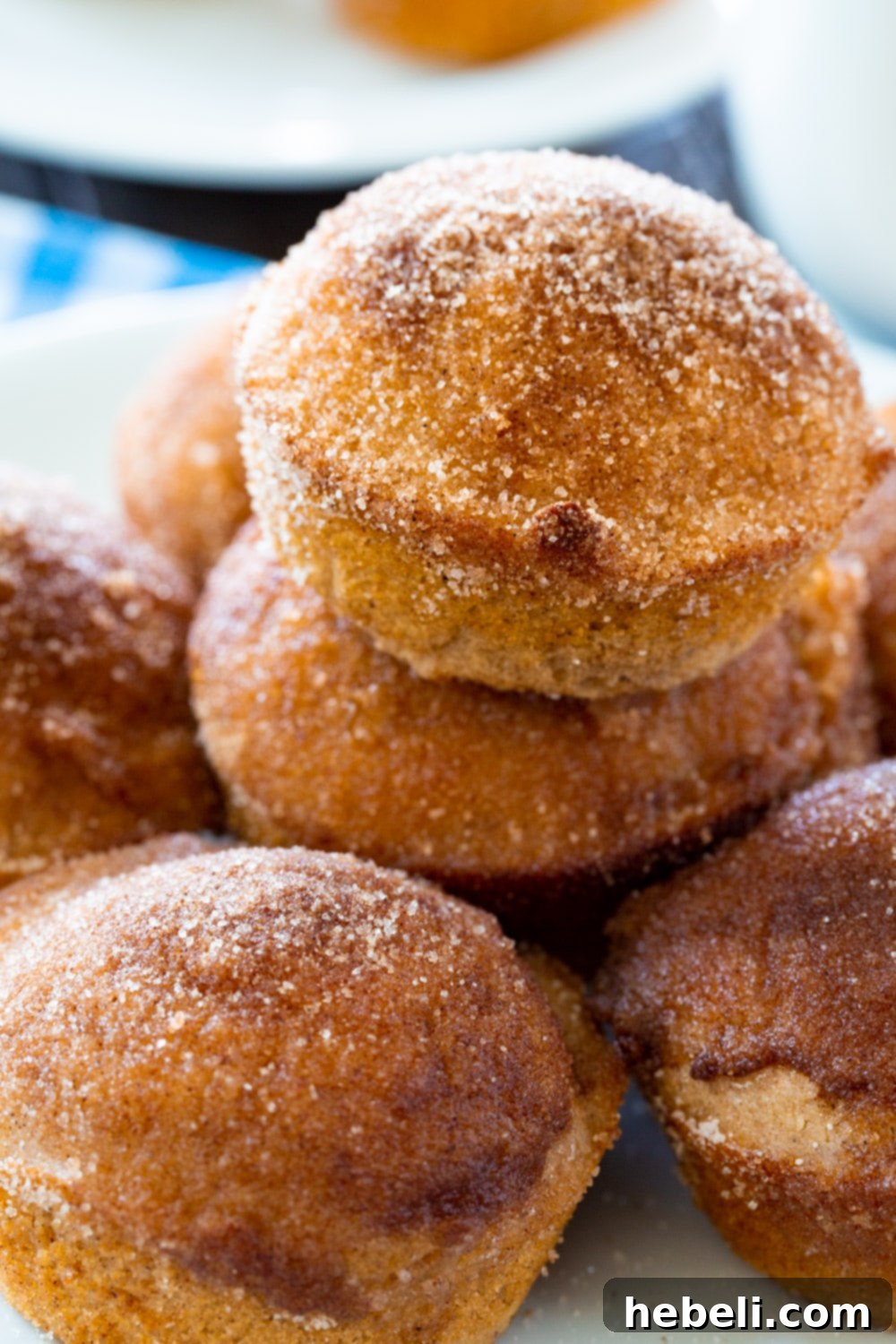 Close-up stack of golden-brown Old-Fashioned Doughnut Muffins coated in sparkling cinnamon sugar.