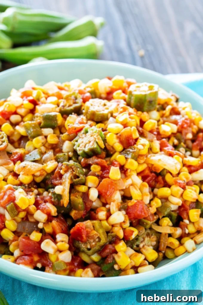 Close-up view of Corn Okra Creole in a shallow serving bowl, garnished with a sprig of fresh parsley, highlighting the dish's vibrant colors and textures.