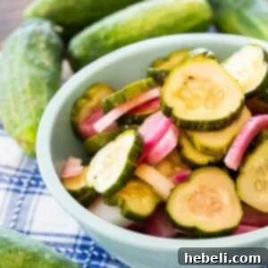 Pickled cucumber slices and onion in a bowl.