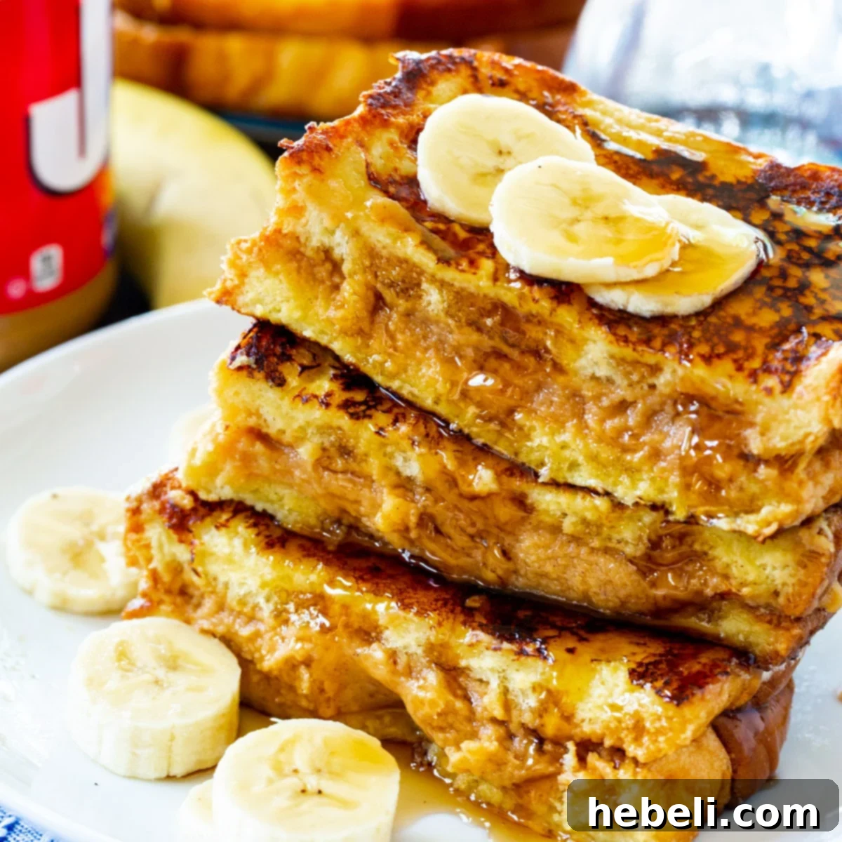 Stacked slices of golden-brown Peanut Butter Stuffed French Toast on a plate, ready to be served.