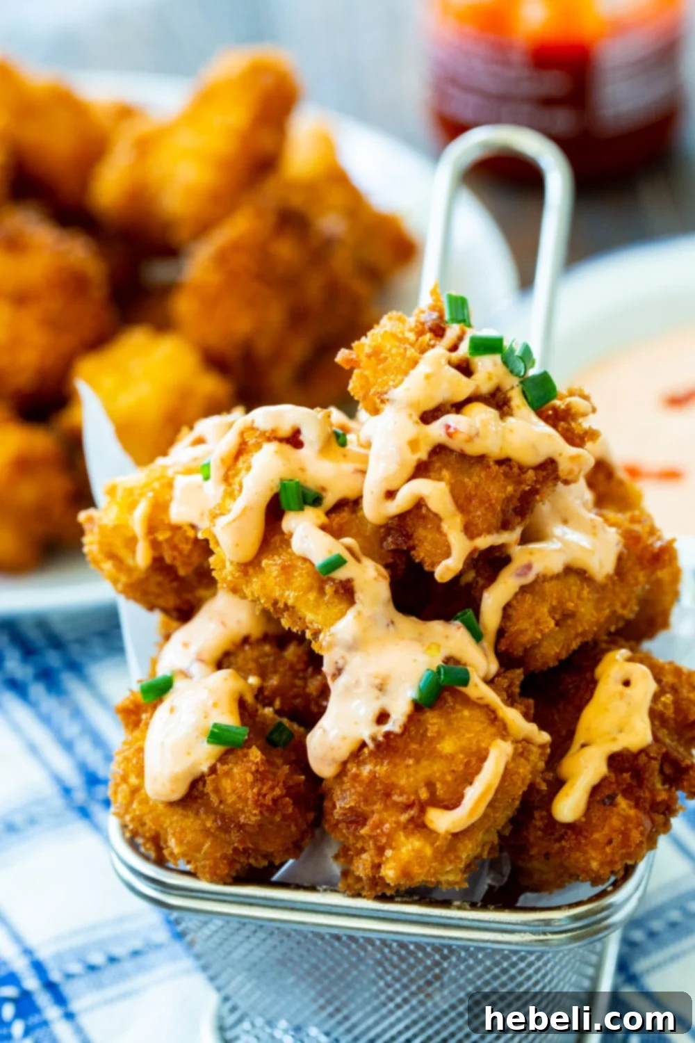 Crispy Bang Bang Chicken in a metal serving basket, ready to be enjoyed.