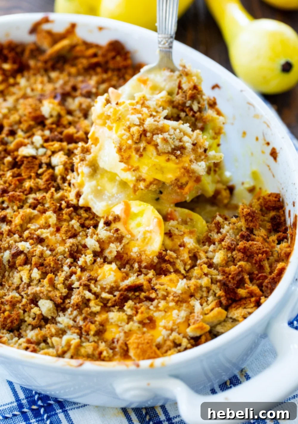 Stuffing-Topped Squash Casserole 3 A spoon scooping a generous portion of creamy Squash Casserole, showcasing its rich texture.