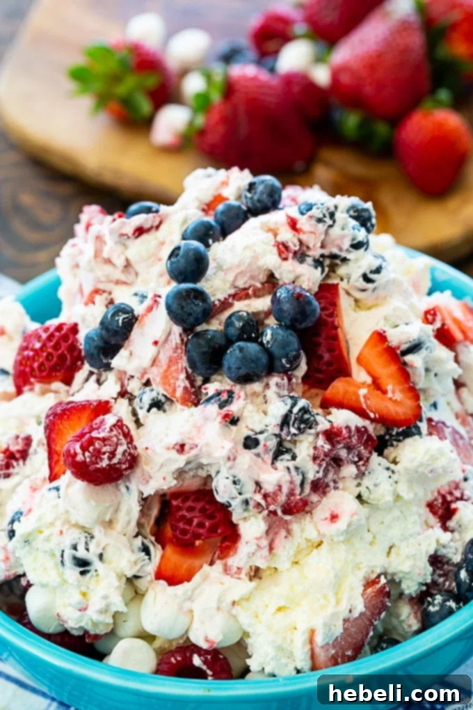 Stars and Stripes Cheesecake Salad 3 A close-up view of the Red, White & Blue Cheesecake Salad, showcasing its creamy texture and an abundance of fresh, vibrant berries.