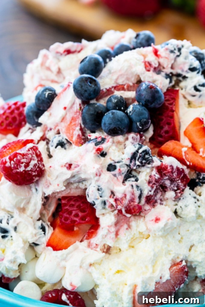 Stars and Stripes Cheesecake Salad 4 A beautifully presented bowl of Red, White & Blue Cheesecake Salad, perfect for a festive gathering, with visible layers of creamy filling and fresh berries.