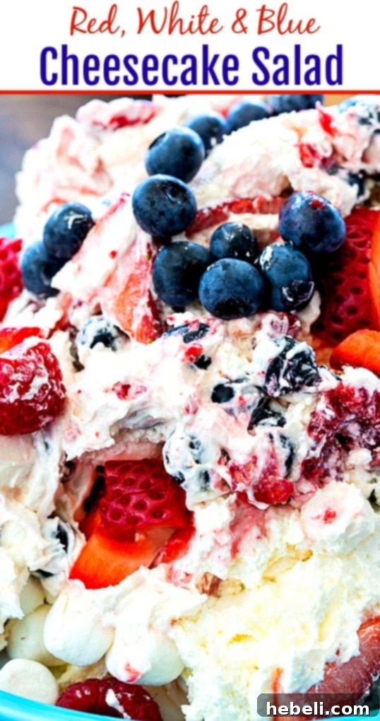 Stars and Stripes Cheesecake Salad 6 An enticing close-up of the Red, White & Blue Cheesecake Salad in a glass dish, highlighting the distinct layers of creamy cheesecake filling and fresh, colorful berries.