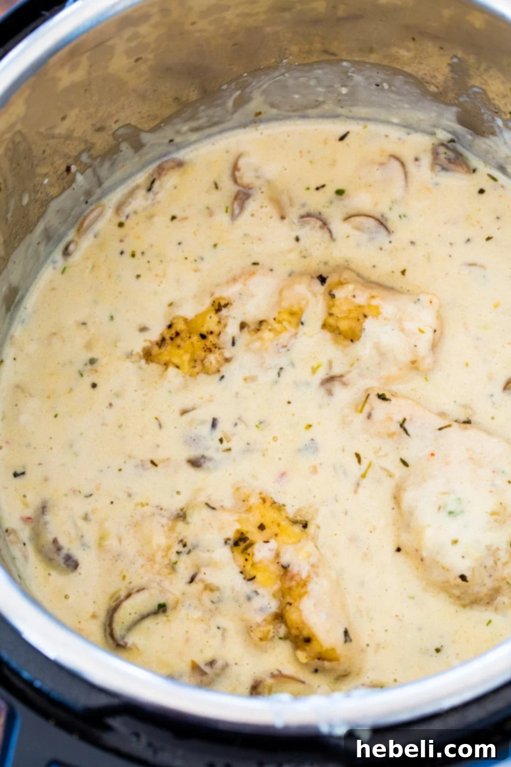 Champagne Chicken cooking in an Instant Pot, showing the rich, bubbly sauce with mushrooms.
