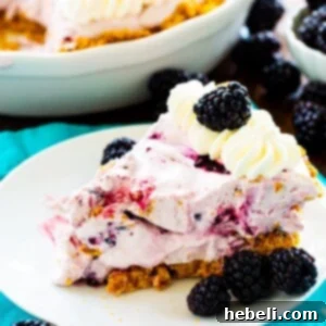 Slice of Blackberry Cheesecake Icebox Pie on a plate with fresh blackberries.