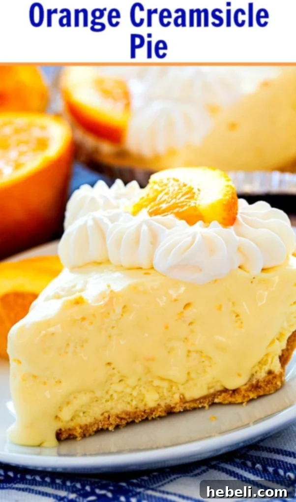 A whole No-Bake Orange Creamsicle Pie with a perfectly set, smooth filling and a golden graham cracker crust, garnished lightly, presented on a rustic surface.
