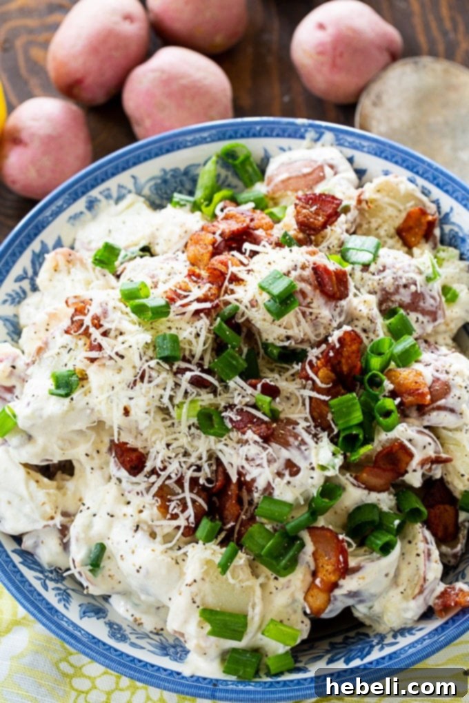 Close-up of Caesar Potato Salad showcasing its creamy texture and vibrant ingredients like green onions and bacon