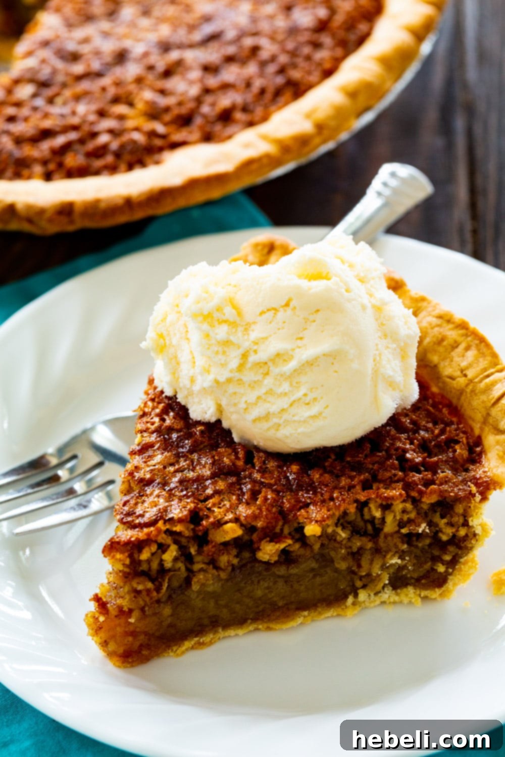 A delectable slice of Oatmeal Pie served on a pristine white plate, showcasing its golden crust and rich, oat-filled center.
