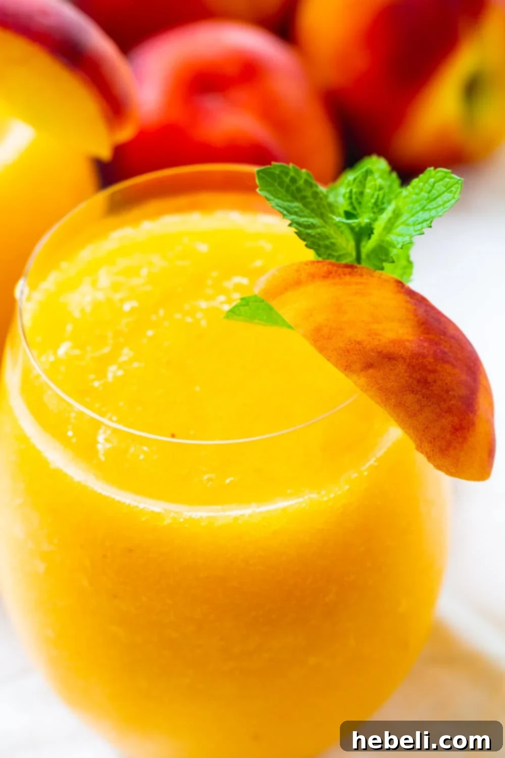 Close-up view of a refreshing Peach Wine Slushie, showcasing its icy texture and the vibrant color of peaches.