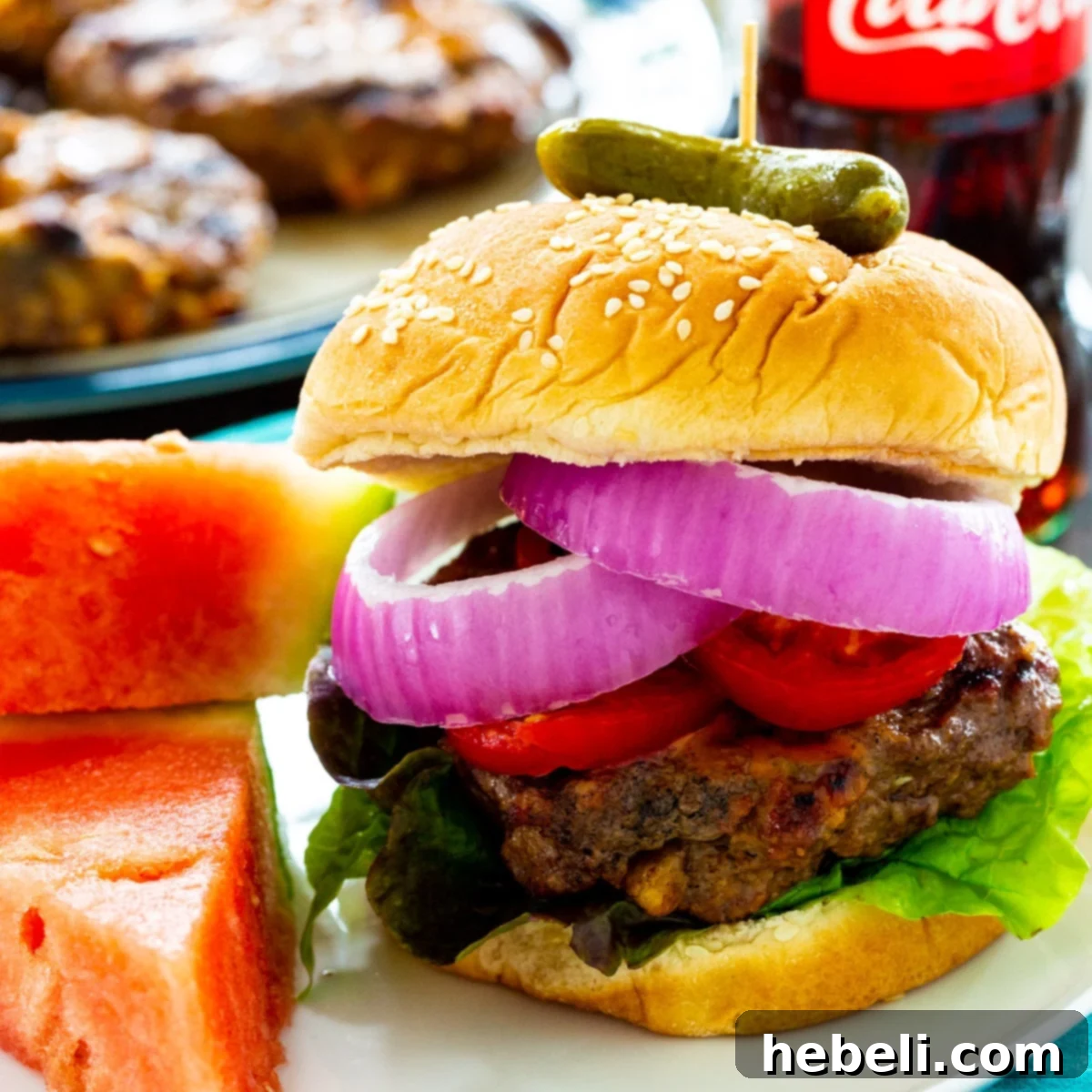 Cola Burgers topped with fresh tomatoes, crisp lettuce, and vibrant red onions on a toasted bun.