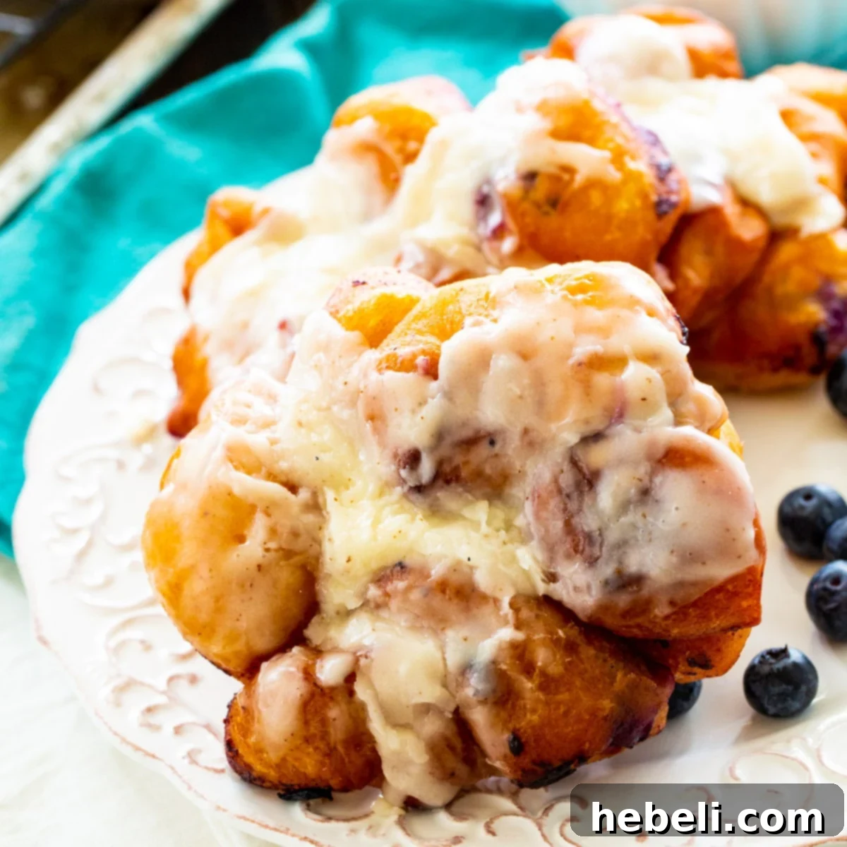 Delicious Blueberry Fritters covered in browned butter glaze, piled high on a white plate, ready to be enjoyed.