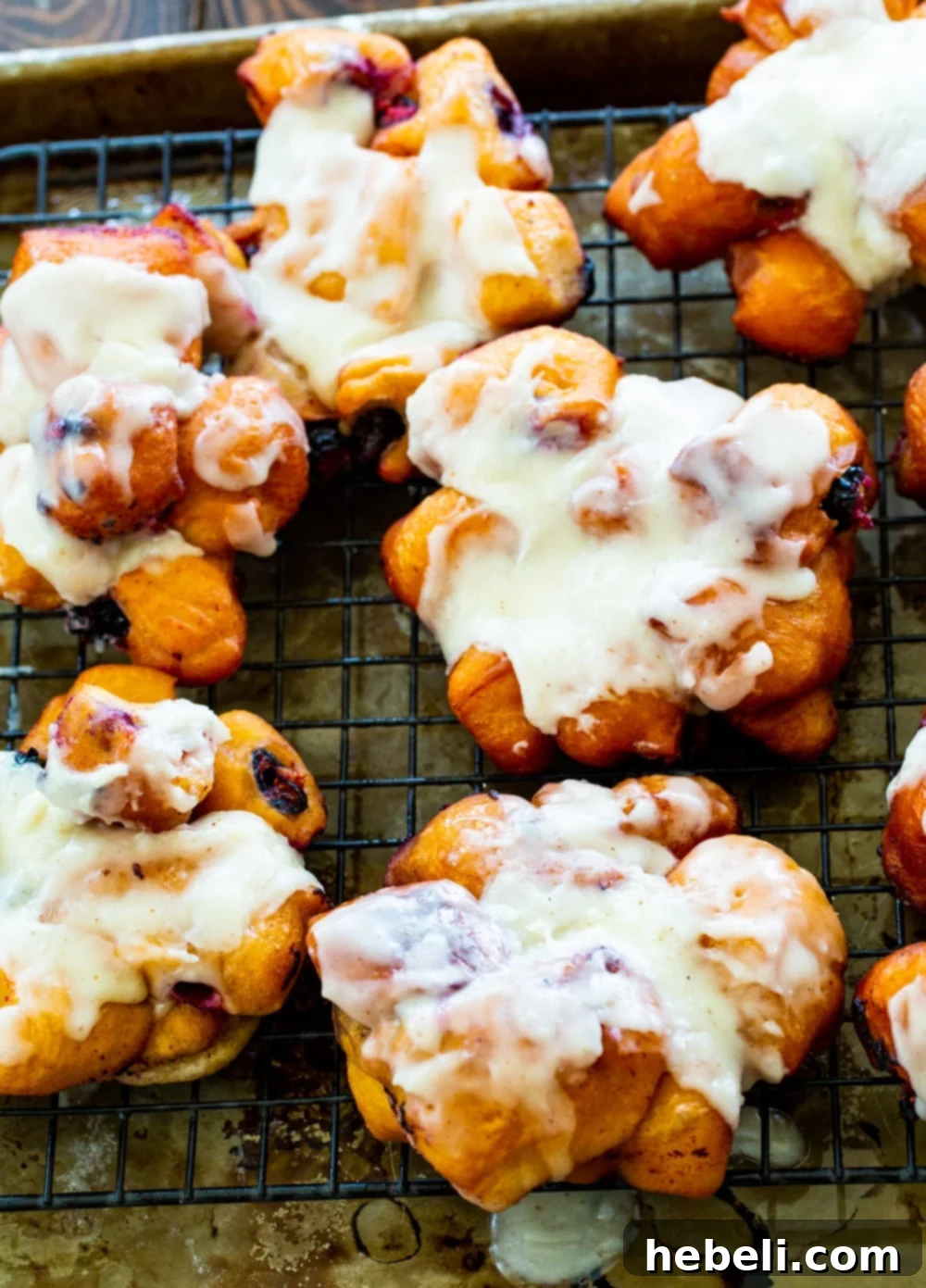 Freshly fried Blueberry Fritters cooling on a wire rack, waiting for their luscious browned butter glaze.