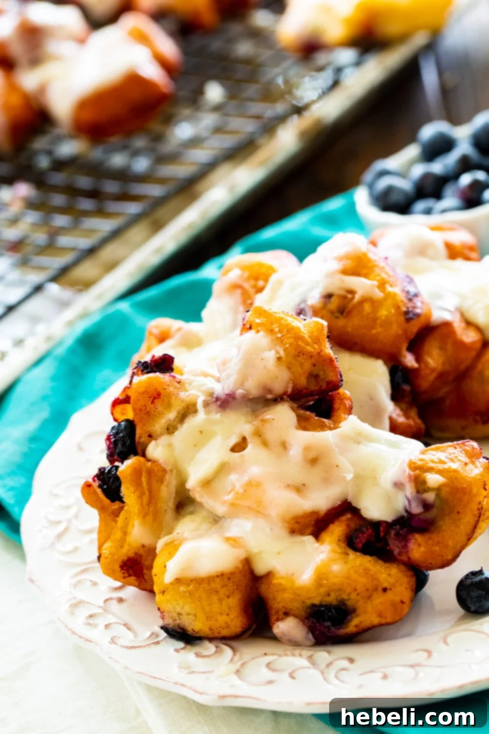A close-up shot of perfectly glazed Blueberry Fritters, showing the soft interior and juicy blueberries.