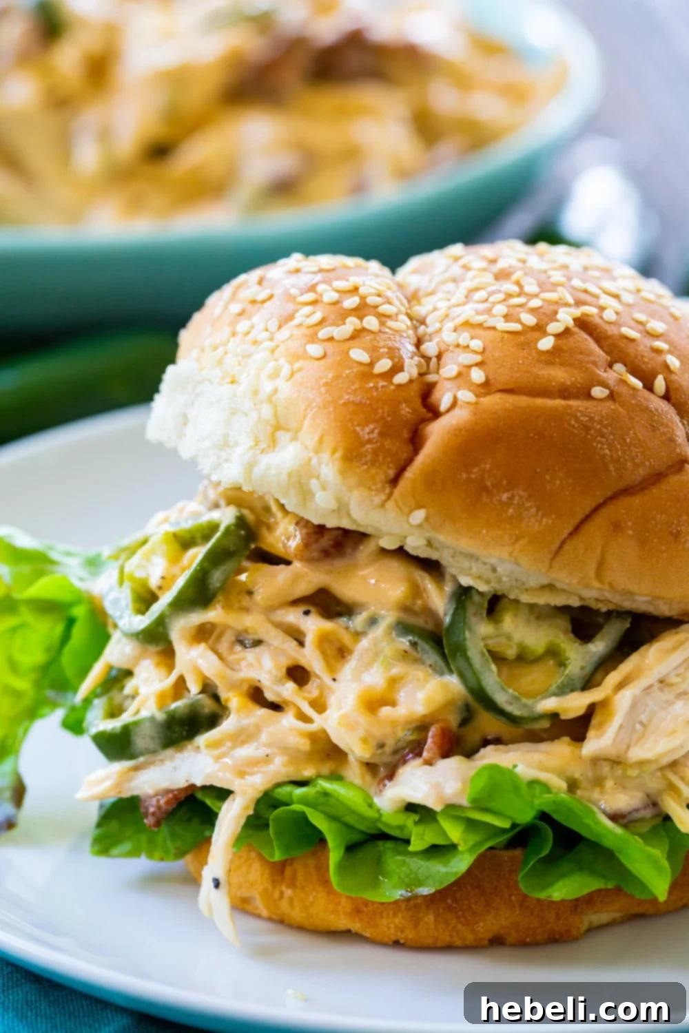 Close-up of creamy and delicious Jalapeno Popper Shredded Chicken piled high on a soft bun, ready to be enjoyed.