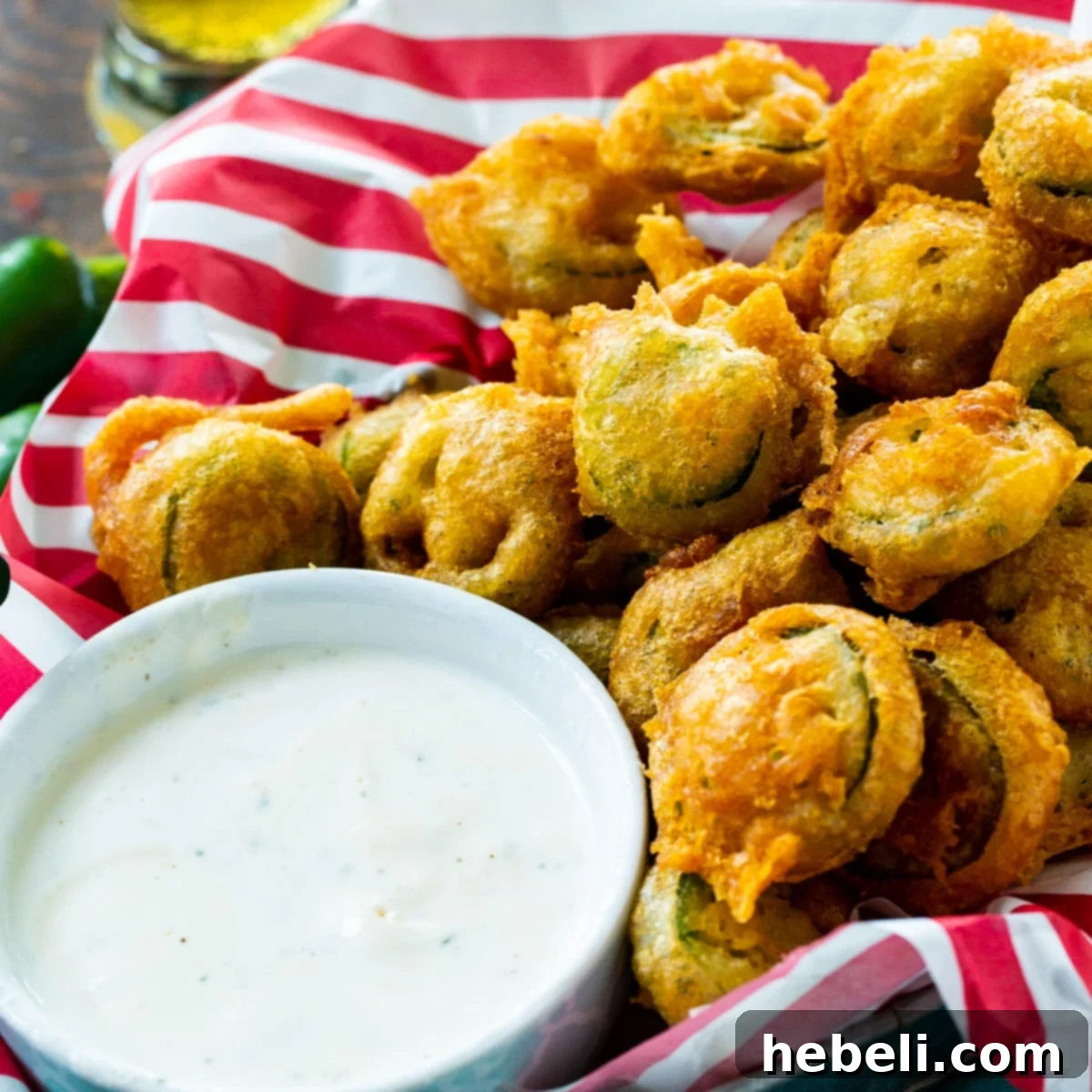 Basket of crispy Deep Fried Jalapeno Slices with a side of cool Ranch dressing, ready to be enjoyed.