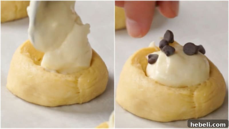 A close-up view of danishes on a baking sheet, with creamy filling and chocolate chips, ready for baking.