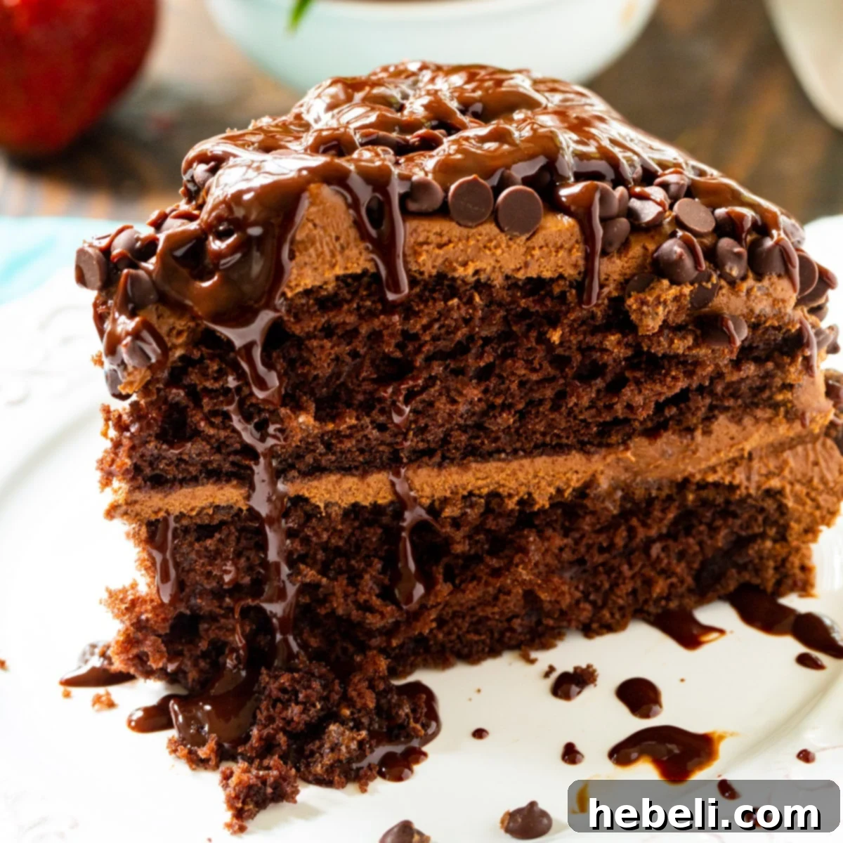 A delectable slice of incredibly fudgy Death by Chocolate Cake, showcasing its moist layers, rich chocolate frosting, and elegant ganache drizzle.