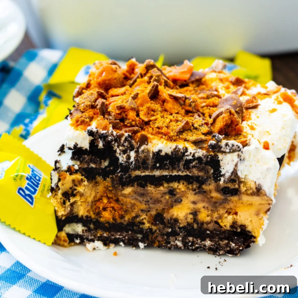 Ultimate No-Bake Butterfinger Oreo Delight 2 A delectable slice of No-Bake Butterfinger Oreo Icebox Cake on a pristine white plate, showcasing its distinct layers.