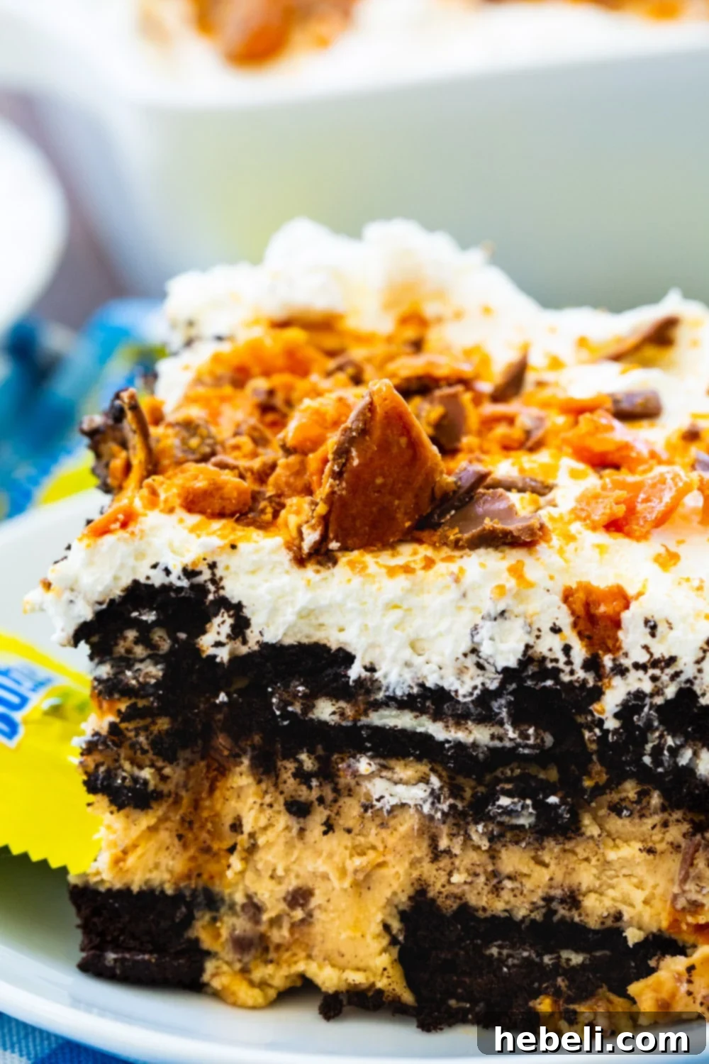 Ultimate No-Bake Butterfinger Oreo Delight 4 A tantalizing close-up view of the finished No Bake Butterfinger Oreo Icebox Cake, showing the whipped cream topping and generous Butterfinger crumbles.