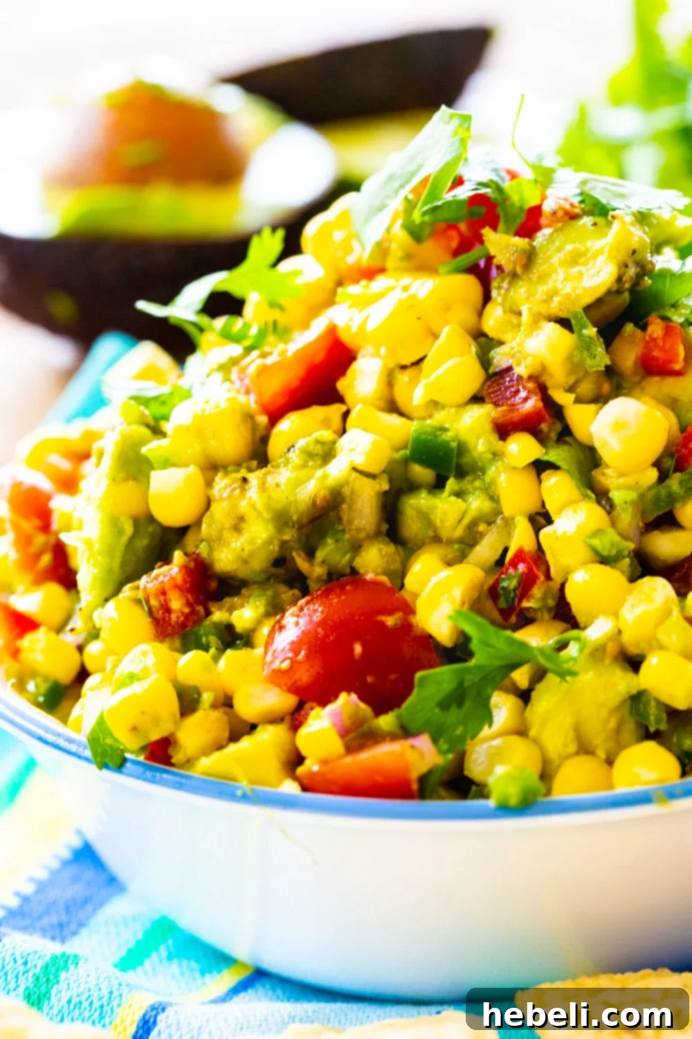 Avocado and Corn Salsa piled high in a rustic bowl, ready for dipping.
