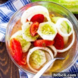Marinated Cucumber, Tomato, and Onion Salad in a glass bowl, ready to be served.