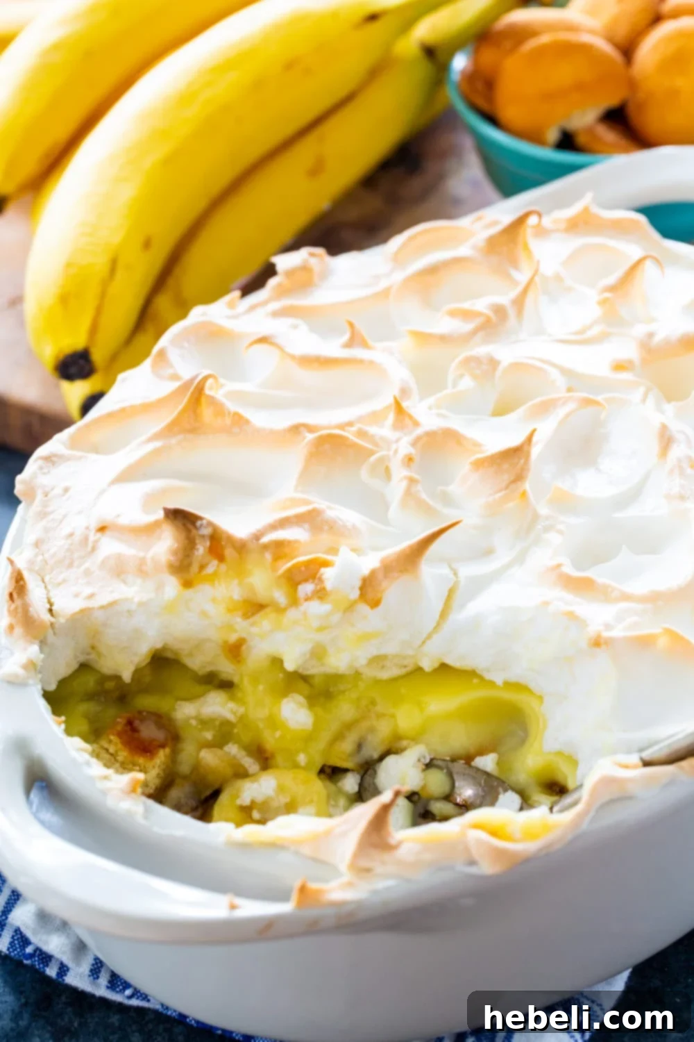Banana Pudding with Meringue in baking dish with a serving scooped out.