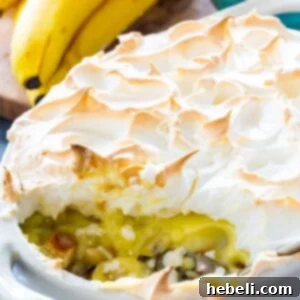Banana Pudding with Meringue in baking dish with a serving scooped out.